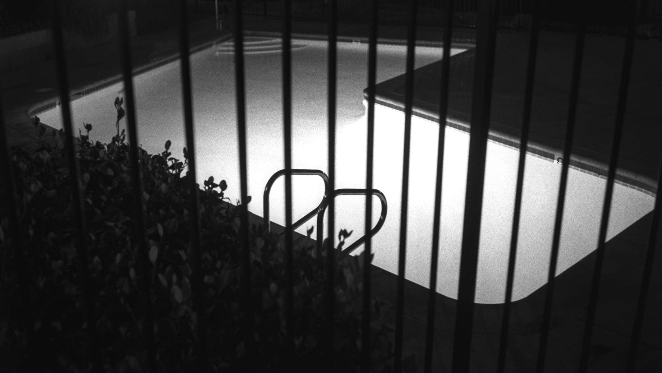 Nachts beleuchteter Pool in Los Angeles, Kalifornien, Foto in schwarzweiss. © Martin Geier