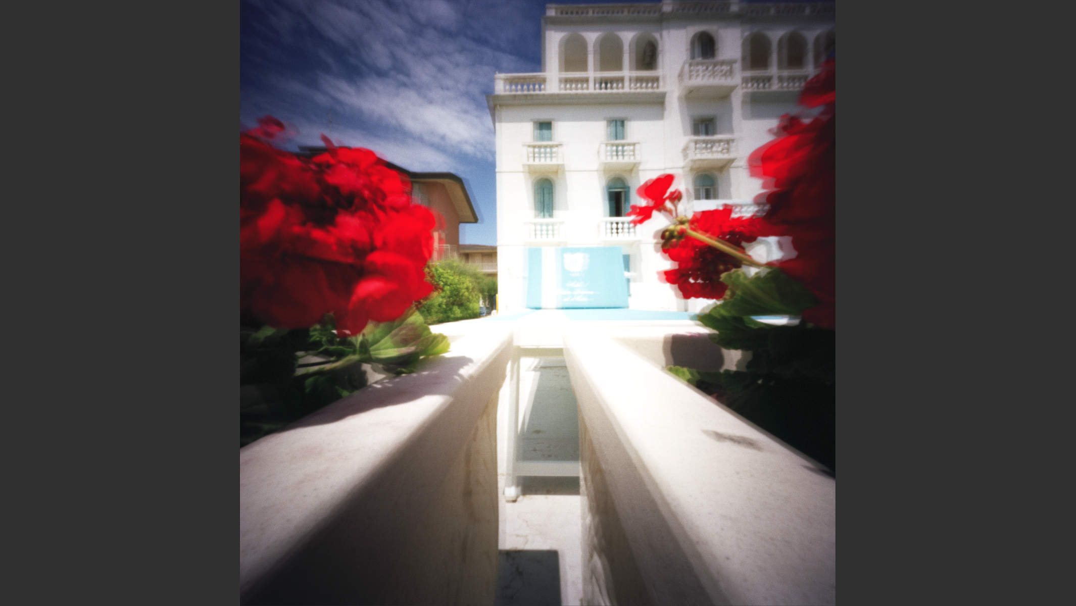 Lochkamera-Foto eines Strandhauses an der Adria mit roten Blumen. © Martin Geier